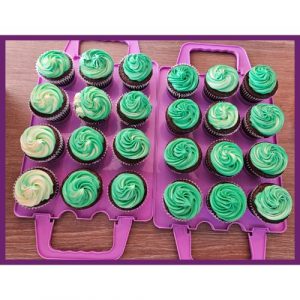 Cupcake Tray: A tray of 24 cupcakes with green and white swirled frosting, neatly arranged.